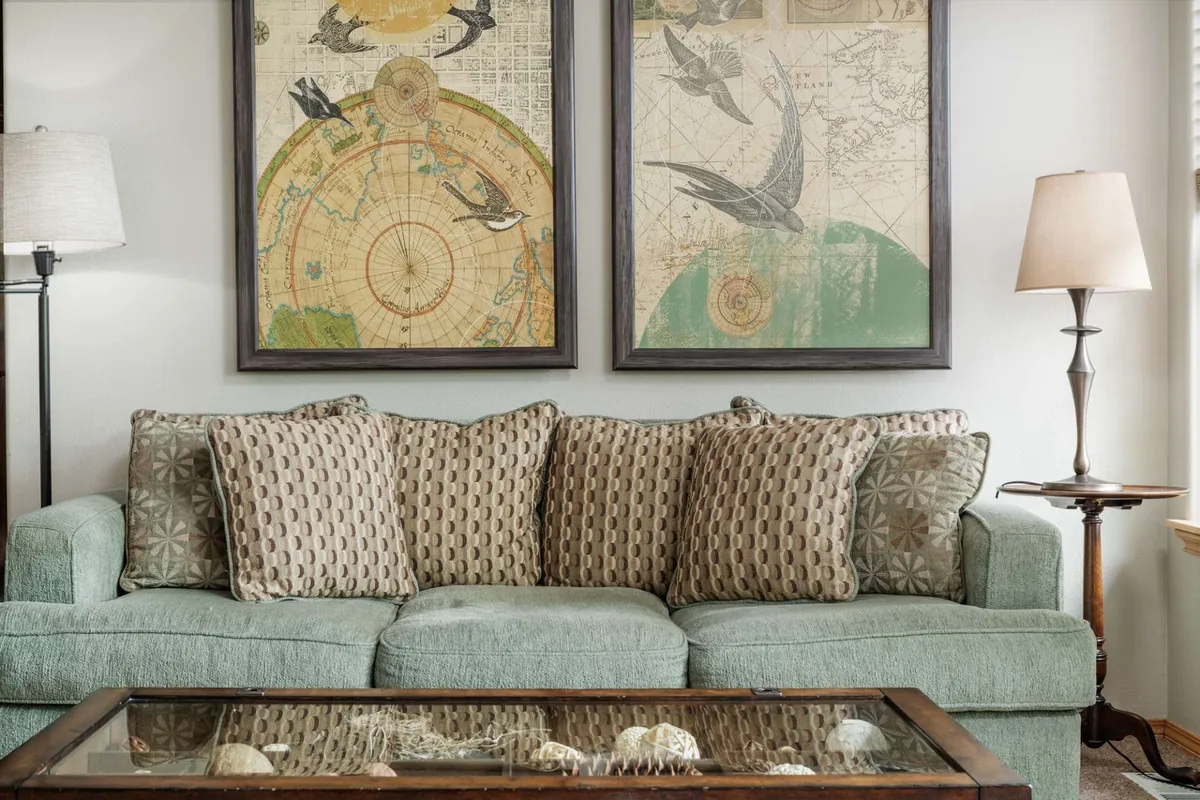 A cozy living area featuring a comfortable sofa, inviting lamp, coffee table, and vibrant artwork. The setting is arranged to encourage relaxation, reading, and casual socializing, with warm lighting creating a tranquil atmosphere.