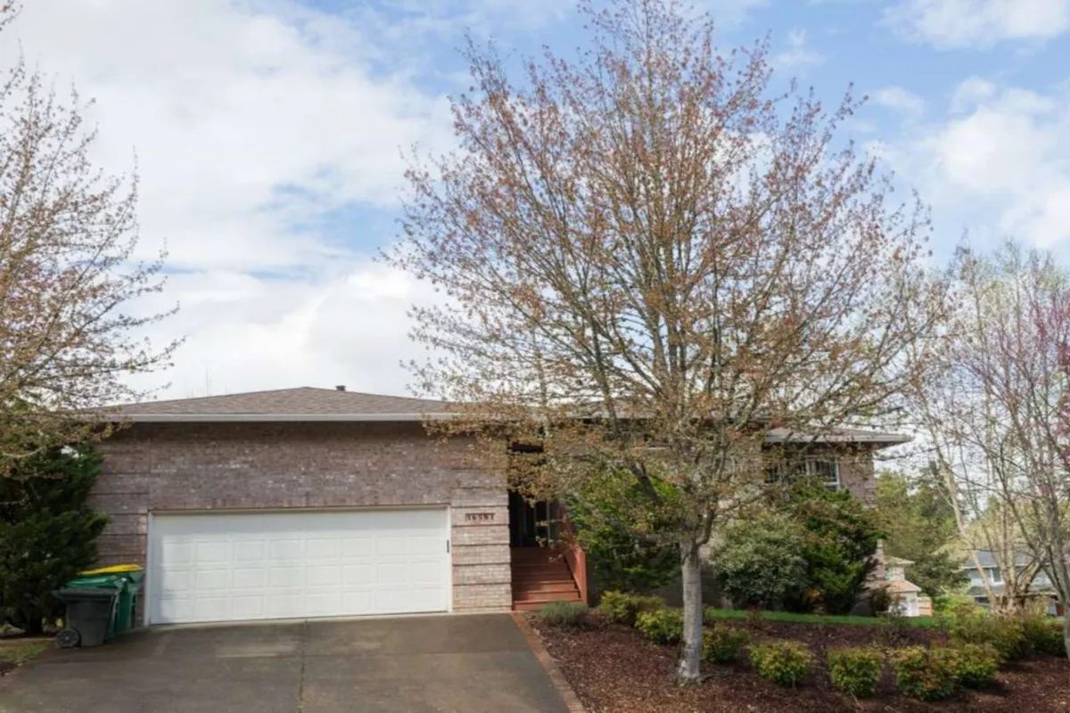 This exterior shot showcases the brick facade of the home, complemented by surrounding mature trees and a glimpse of the front steps. The setting hints at a peaceful, green environment and an inviting transition from indoor spaces to the outdoors—ideal for family gatherings and outdoor enjoyment.
